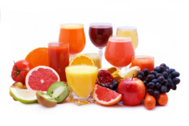 Glasses of fruit and vegetable juice with fruits on a white background