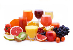 Glasses of fruit and vegetable juice with fruits on a white background